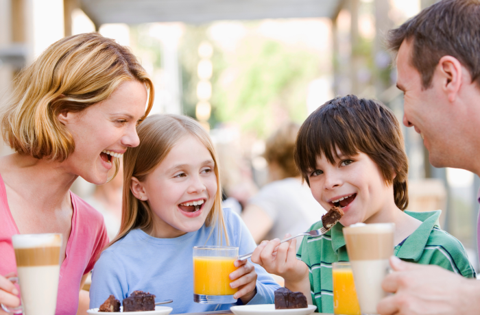 Family laughing having coffee and cake 