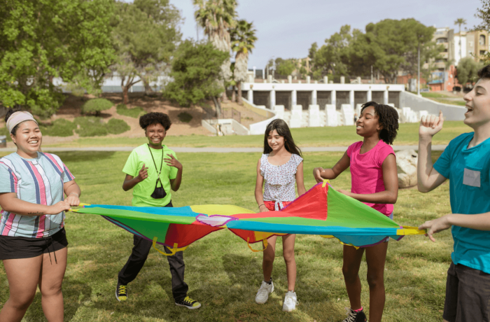 5 children having fun with a multicoloured parachute.
